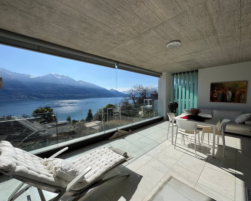 Balcony with glass walls, white chairs and dining table, chaise lounge, couch, white tiled floor