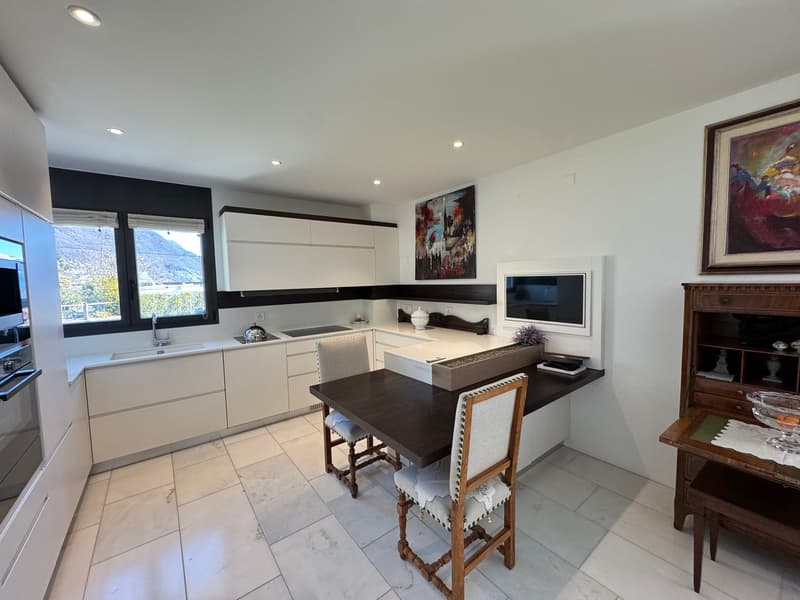 modern kitchen, white cabinets, dark wood table, white tiles, large windows, views of mountains