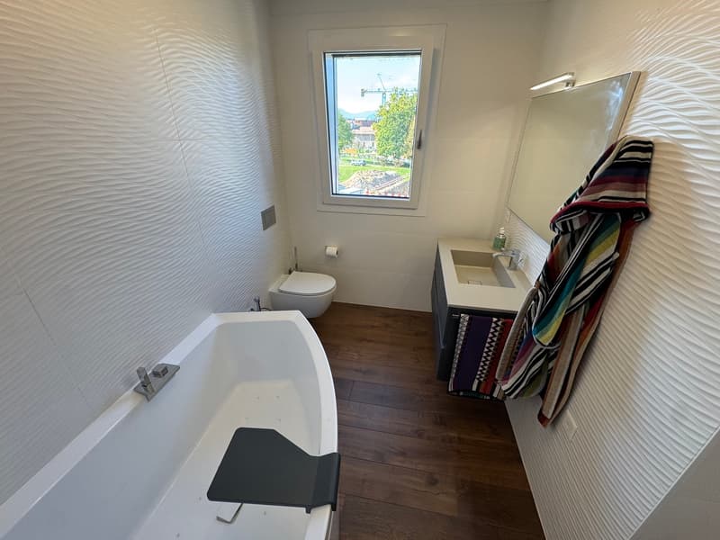 Bathroom with bathtub, toilet, sink, mirror, and towel rack