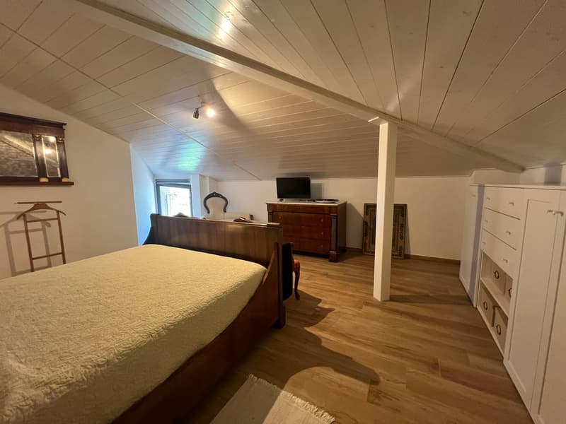 bedroom with wooden bed, wooden dresser, TV, wooden chair, wooden hanger, wooden floor, white walls, white ceiling, window
