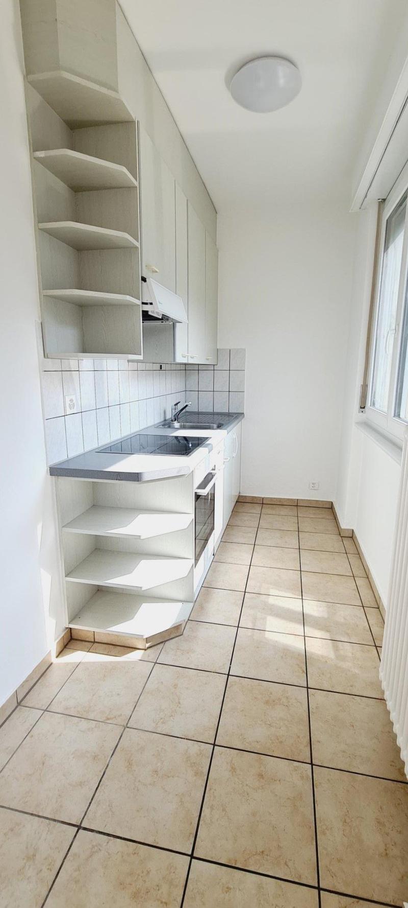 white tiles, wooden cabinets, tiled floor, sink, window