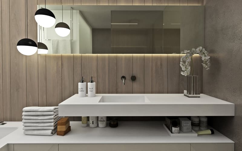 modern bathroom with wooden wall, white countertop, large mirror, white flowers, white towels, white sink, white cabinets, white lights