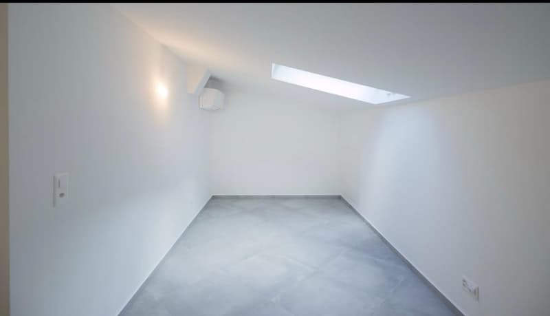 empty room, white walls, gray floor, skylight, wall-mounted speakers, power outlets