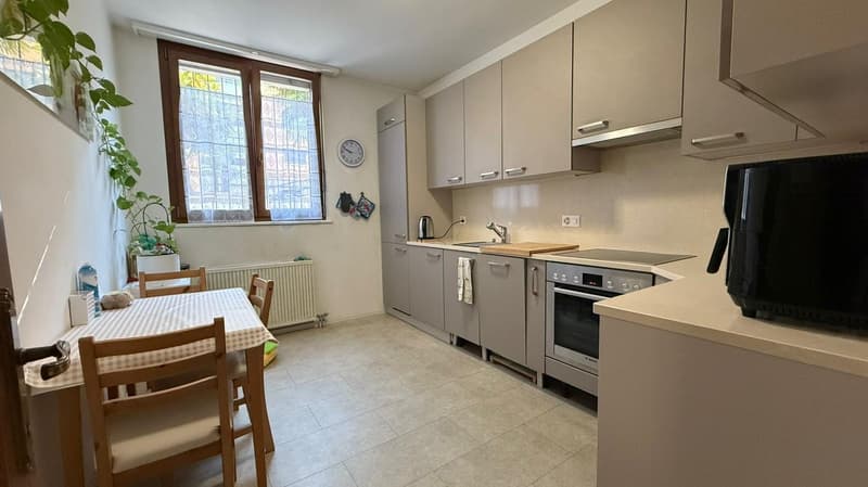 small kitchen with built-in oven, sink, countertop, refrigerator, dining table, potted plant