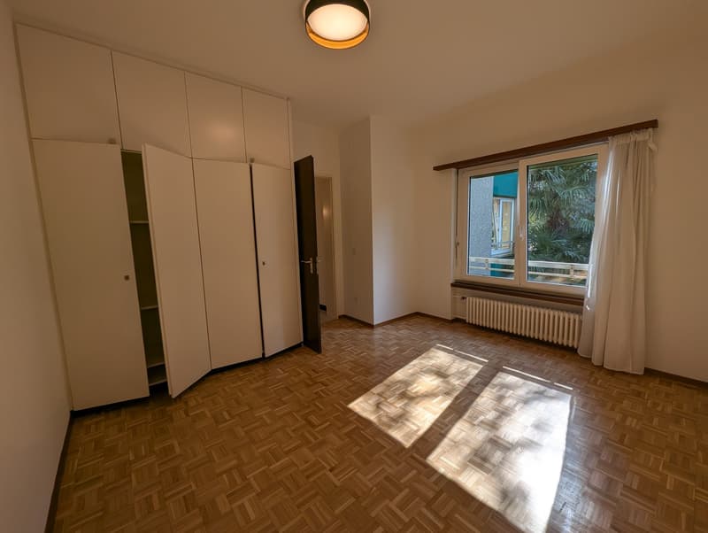 Wooden floor, white cabinets, bright room, window with balcony, radiator