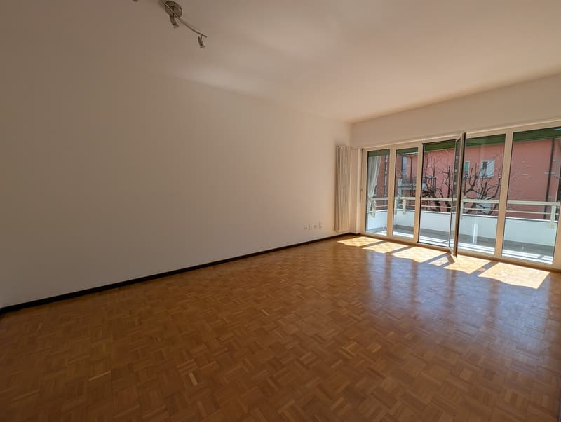 empty room, wooden floor, white walls, sliding glass doors, balcony