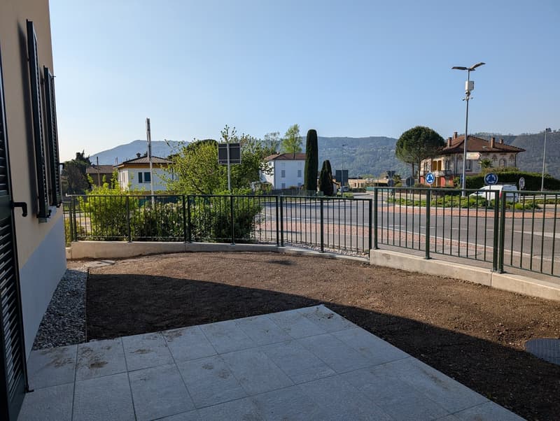 A paved area with a view of a road and mountains in the distance