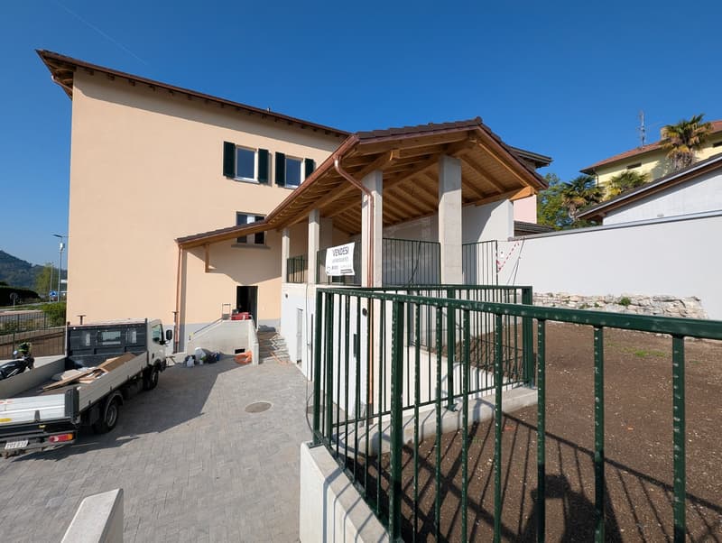 modern house, beige walls, brown roof, large windows, green railings, truck parked in front