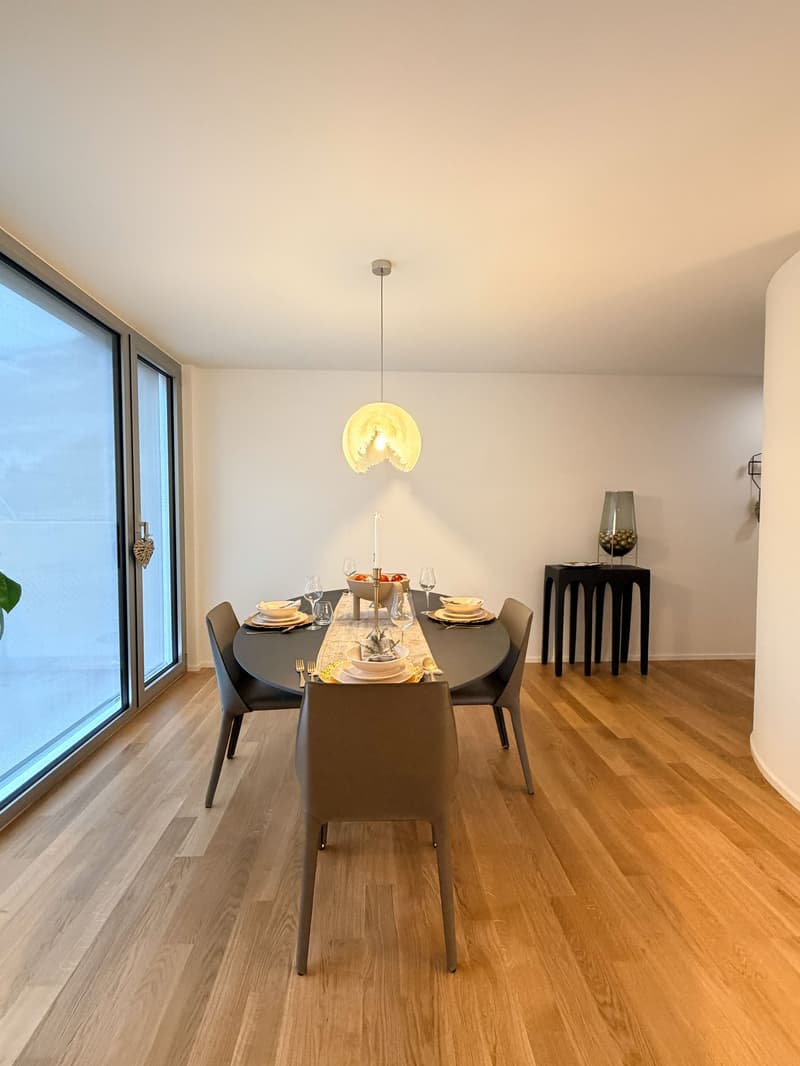 dining room with table, chairs, wooden floor, sliding glass door, and lamp