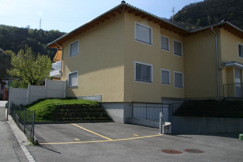 2 story yellow house, white shutters, garage, parking place