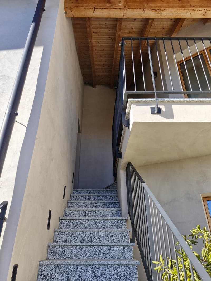 concrete exterior wall, marble steps, wood beams, handrail, balcony