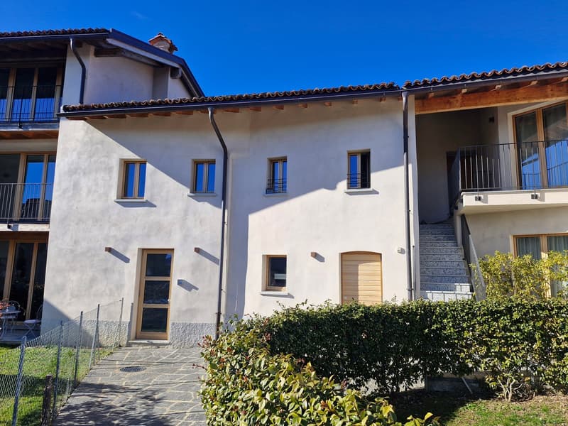Two story apartment, white stucco walls, large windows, wooden doors, two balconies