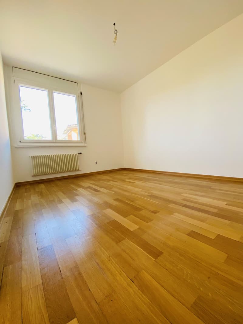 empty room, wooden floor, white walls, large window, white radiator