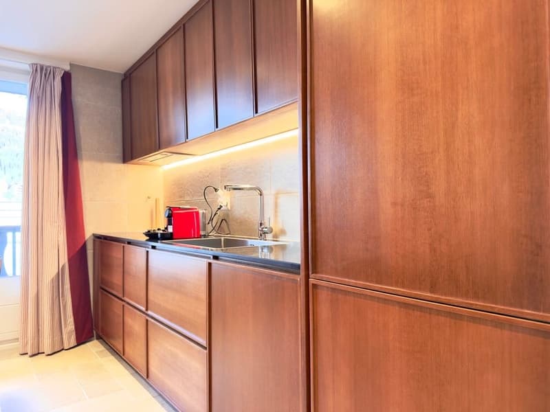 modern kitchen with wooden cabinets, granite countertop, stainless steel sink, faucet, red toaster, tiled floor