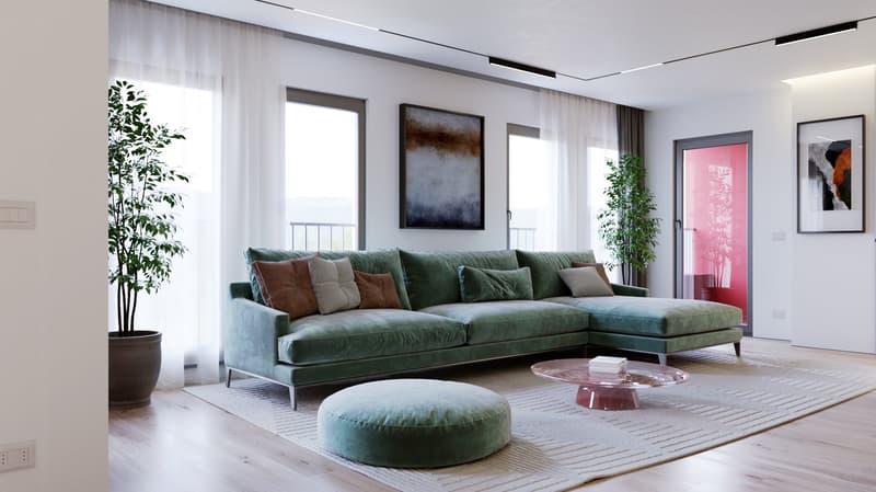 Spacious living room with large windows, green velvet sectional sofa, abstract artwork, potted plants, and a round pink coffee table.
