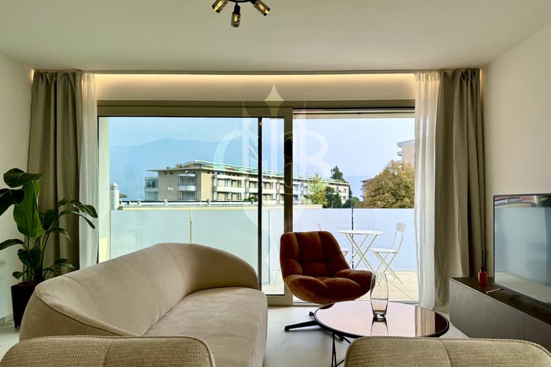 Large window, balcony, couch, chair, table, TV