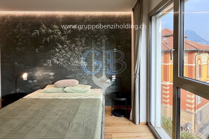Single bed, side tables, floor lamps, grey walls, white curtains, windows, wooden floor