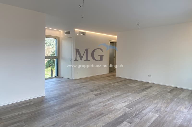 Empty room, hardwood floors, white walls, glass windows, power outlets, no furniture.