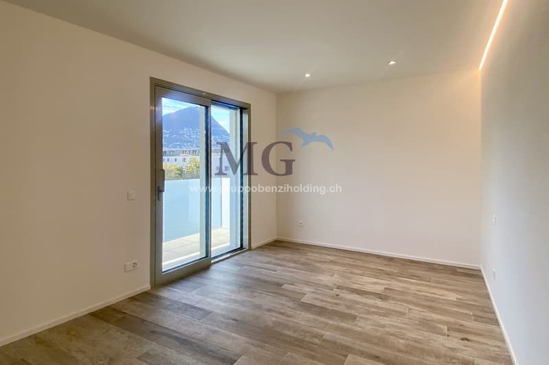 empty room, large sliding glass door leading to balcony, white walls, hardwood floor, balcony with views