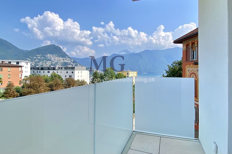 Large balcony, glass railings, stunning mountain views, modern architecture