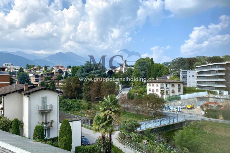 View of buildings in a hilly area with mountains in the background