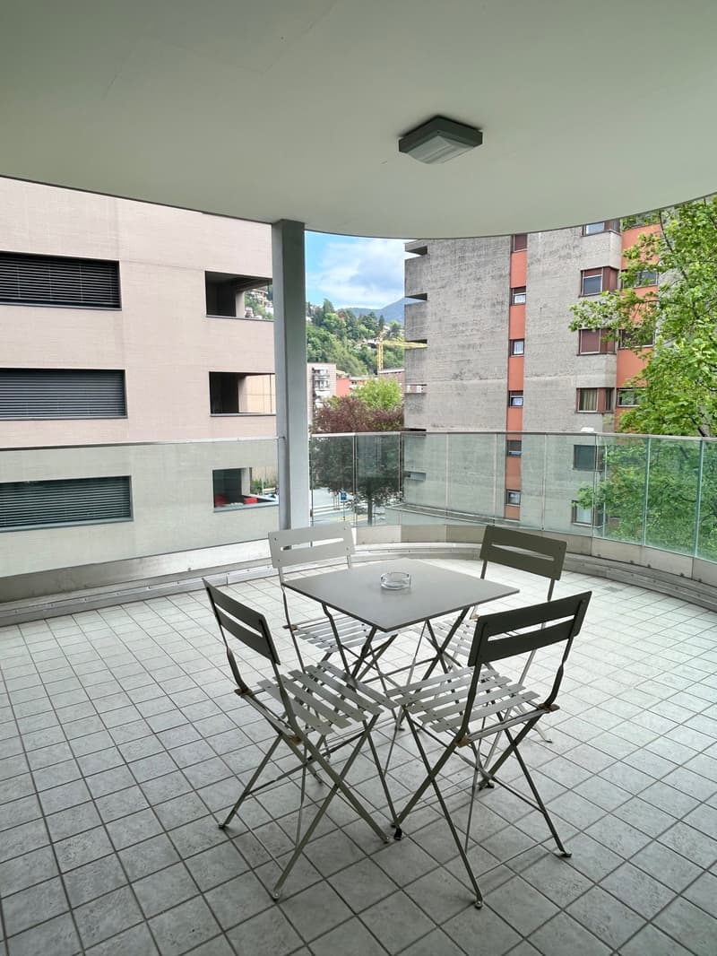 tiled floor, glass railing, table and chairs, city view