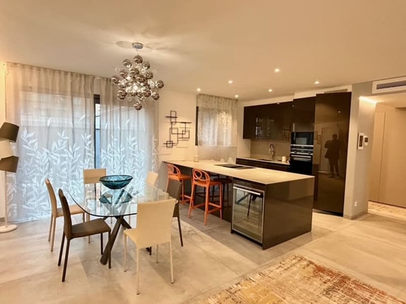 open plan kitchen with a dining table, island with barstools, chandelier, windows with curtains, rug, chandelier, rug