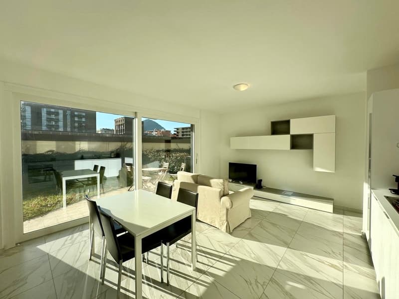 modern dining room with large windows, a couch, a TV, and a table