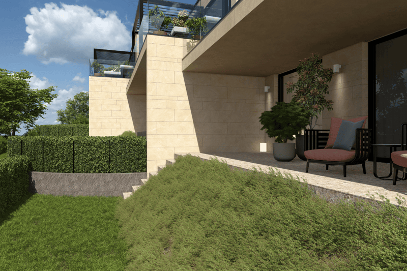 Multi-story apartment building with stone facade, balconies, and landscaped outdoor areas including a grassy lawn and potted plants. There is also a paved area that appears to be a parking space or driveway.