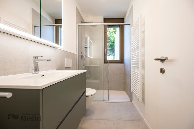 modern bathroom with shower, toilet, sink, mirror and heating system