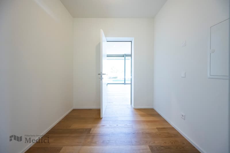 Modern and minimalist hallway with a glass door leading to the balcony.