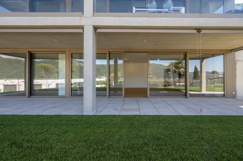 Modern house with glass walls, large windows, terrace, polished stone floor, lawn