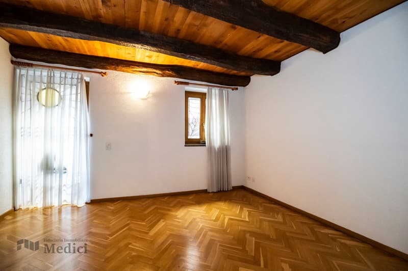 empty room with wooden floor, white walls, wooden beams on ceiling, white curtains, lamp