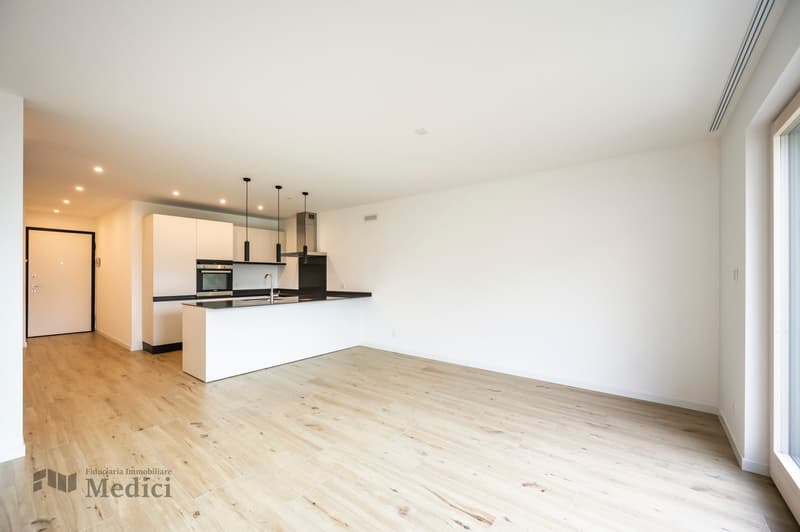 empty kitchen with kitchen island, white cabinets, wooden floor, white walls, natural light