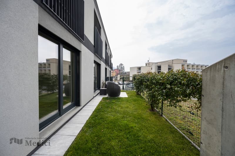 exterior wall with large windows, garden with lawn, patio with outdoor seating