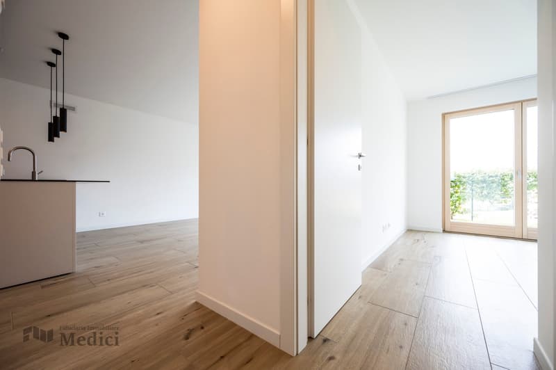 empty room, hardwood floors, open doorway, glass door, sink, ceiling lights