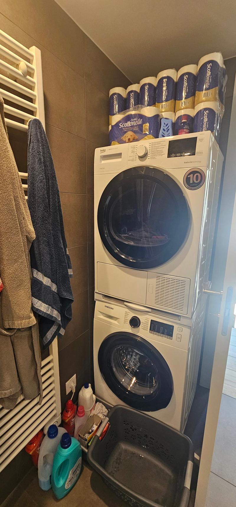 Stacked washing machines, drying rack, cleaning products, towels