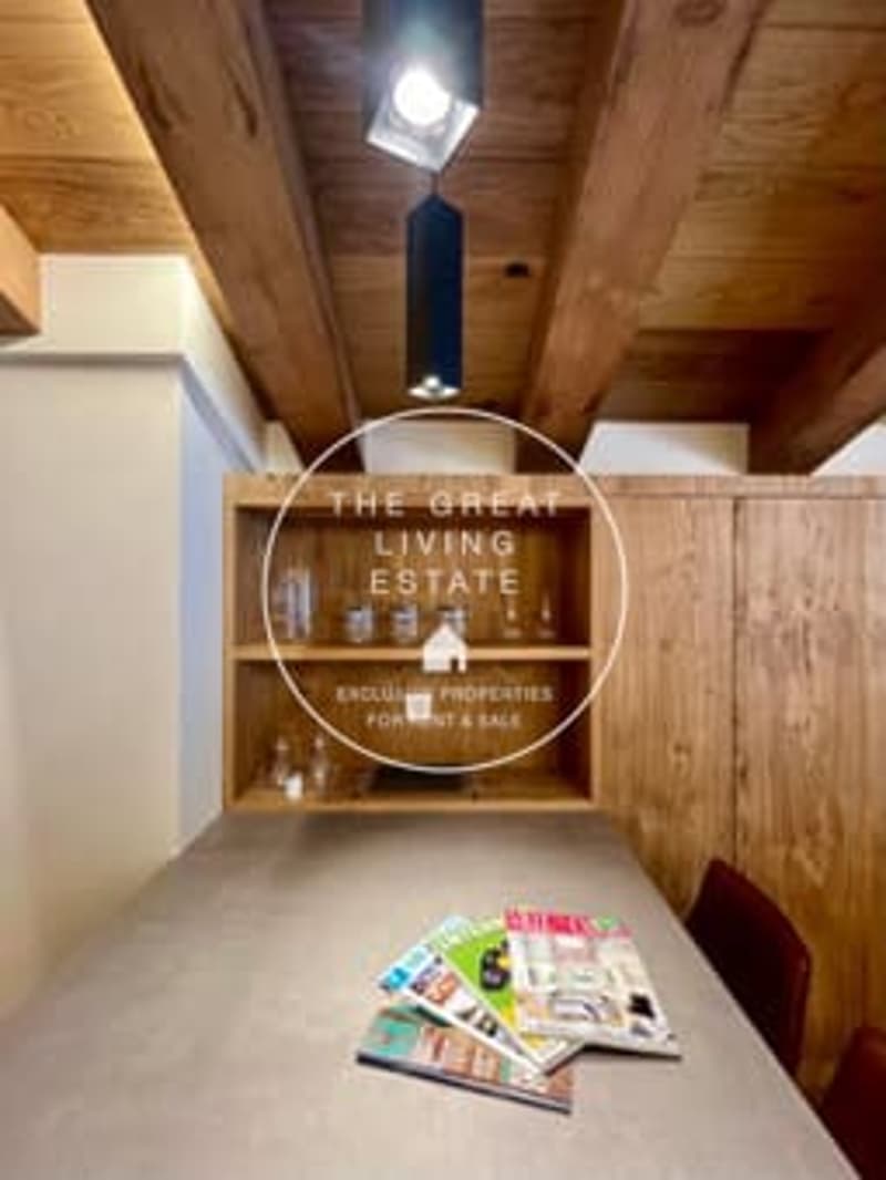 Rustic wooden ceiling, fireplace, decorative sign on the wall, magazines on the floor