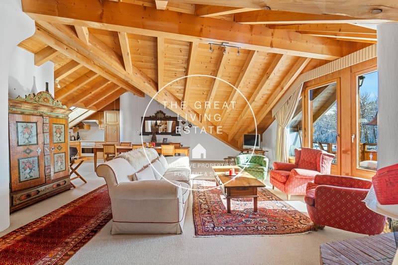 Spacious living room with high wooden ceiling, large windows, plush sofas and armchairs, antique wooden furniture, and a fireplace