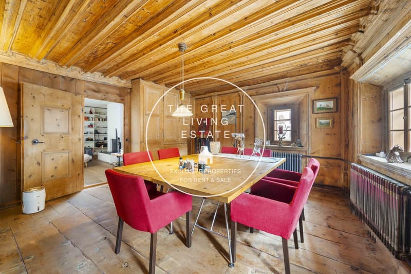 wooden floor, wooden walls, dining table, red chairs, pendant light, radiator, picture frames on the wall