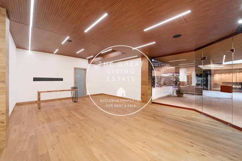 large empty room, wooden floor, wooden wall, glass wall, wooden desk, grey door