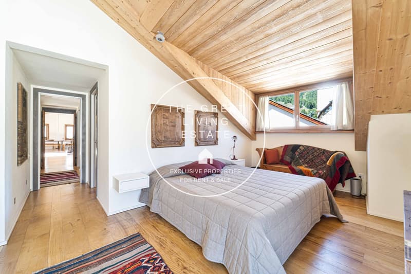 bedroom with bed, couch, small table, and window