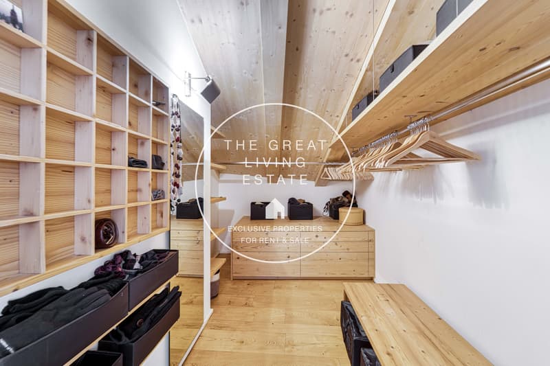 Closet with wooden shelves, storage boxes, drawers, and wooden hangers