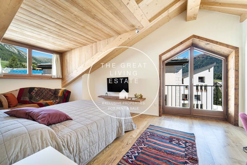 attic bedroom with large windows, balcony, double bed, couch, television