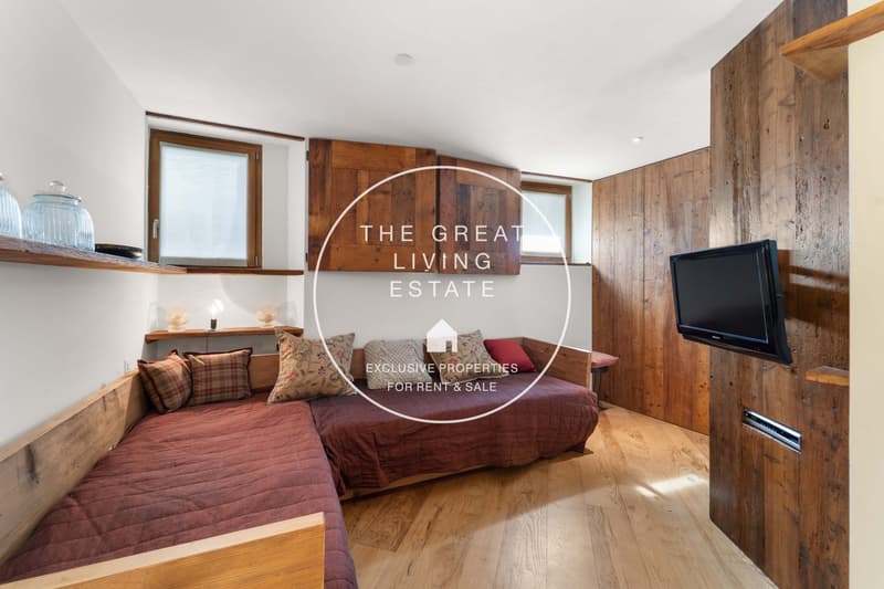 L-shaped bed, wooden floors, wooden walls, mounted television, shelves, windows