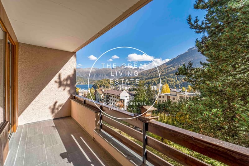 Terrace with wooden railings, overlooking mountain and lake