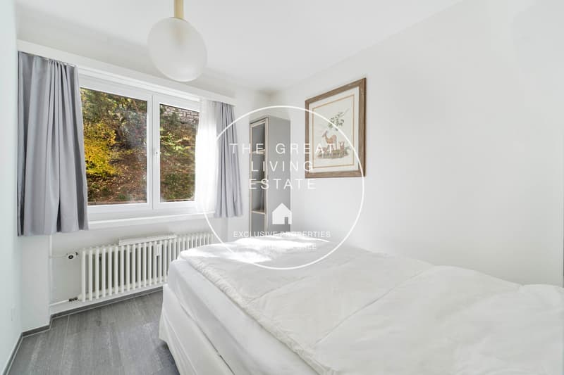 white walls, double bed, large window, radiators, lamp, curtain, picture frame