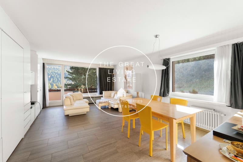 modern interior, wooden floor, large windows, yellow chairs, white couch, wooden table, radiators, kitchen area