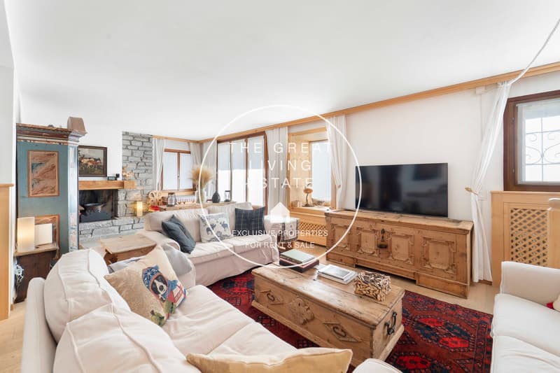 white sofas, fireplace, TV, coffee table, wooden cabinet, windows