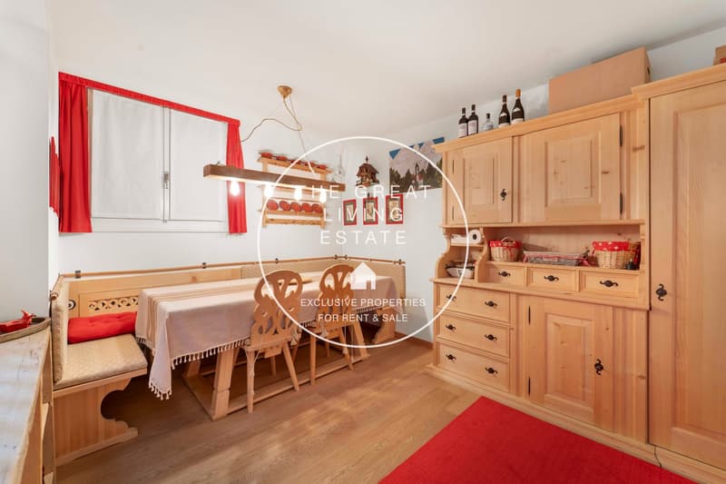 dining area with a table, chairs, bench, rug, lamp, cabinets, wine bottles